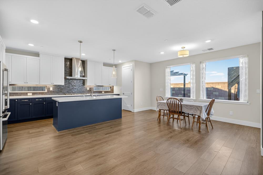 12086 Mircado Way Rancho Cordova, CA 95742 - Photo 18 of 84 a large kitchen with stainless steel appliances granite countertop a stove a sink a dining table and chairs