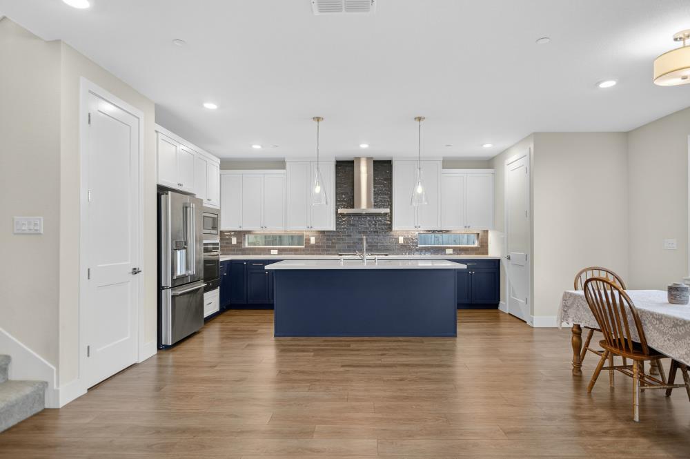 12086 Mircado Way Rancho Cordova, CA 95742 - Photo 19 of 84 a large kitchen with stainless steel appliances granite countertop a refrigerator a stove a sink a dining table and chairs