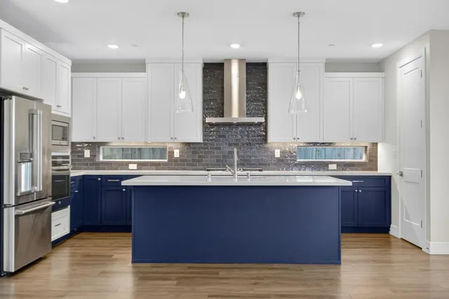 a kitchen with stainless steel appliances a refrigerator and a stove top oven