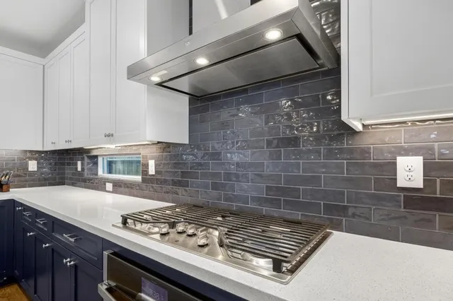 a kitchen with stainless steel appliances granite countertop a refrigerator and a stove top oven