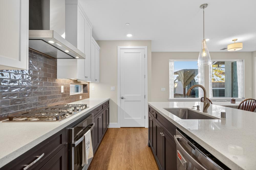 12086 Mircado Way Rancho Cordova, CA 95742 - Photo 28 of 84 a kitchen with stainless steel appliances granite countertop a sink a stove and a wooden floors