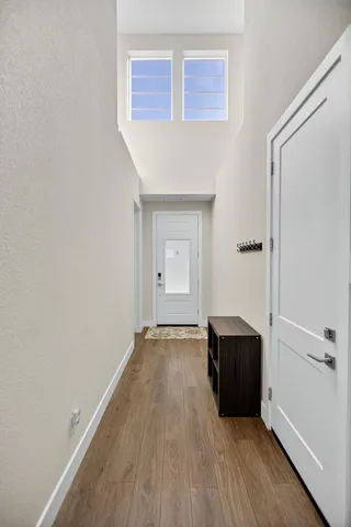 a living room with couches and kitchen view with wooden floor