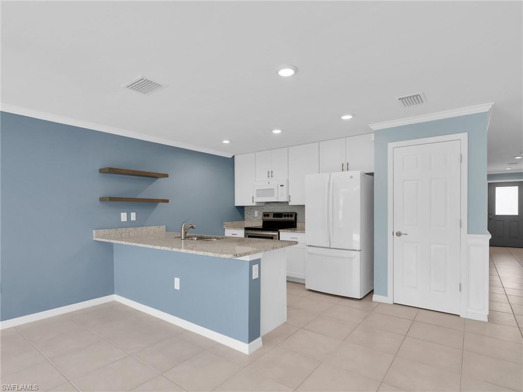 731 Hadley Place West Naples, FL 34104 - Photo 15 of 30 Dining Area and Kitchen With White Shaker Cabinets, Island, Granite Countertops, Added Backsplash, Pantry, New White GE Dishwasher, Microwave, and Refrigerator With Icemaker, and Stainless Steel Frigidaire Range With Self-Cleaning Oven