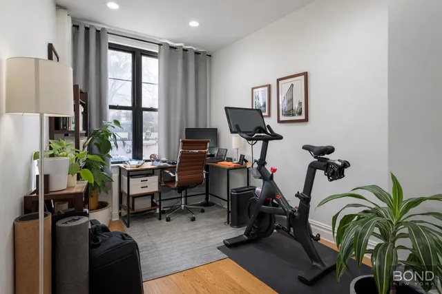 a view of a workspace with furniture and a window