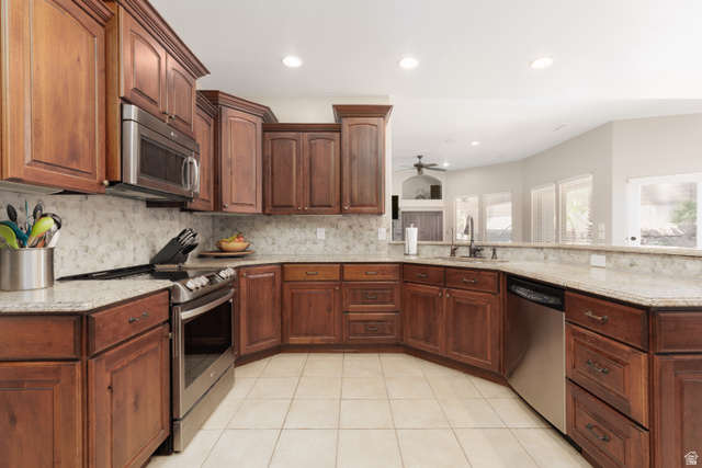 1257 West 2320 South St. George, UT 84770 - Photo 11 of 55 Kitchen featuring wood cabinetry, light-toned countertops, tile flooring, stainless steel appliances, and a built-in microwave