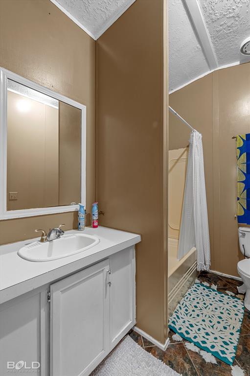 9720 Osburn Road Shreveport, LA 71129 - Photo 18 of 30 Vanity with white cabinetry and an integrated sink, framed mirror, and a built-in shower-over-tub combination