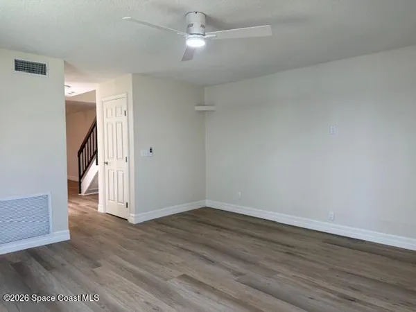 a view of an empty room with wooden floor