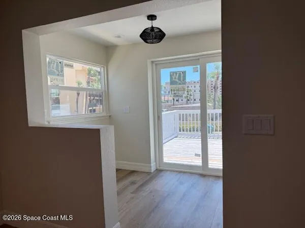 an empty room with wooden floor and ceiling fan