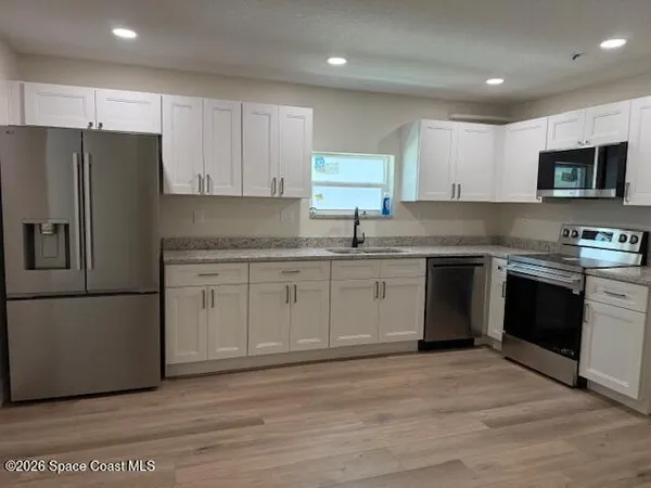 a kitchen with stainless steel appliances granite countertop a refrigerator sink and cabinets