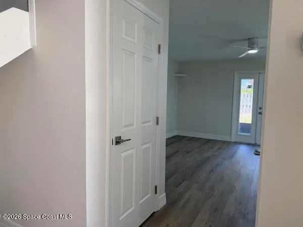 a view of a hallway with wooden floor