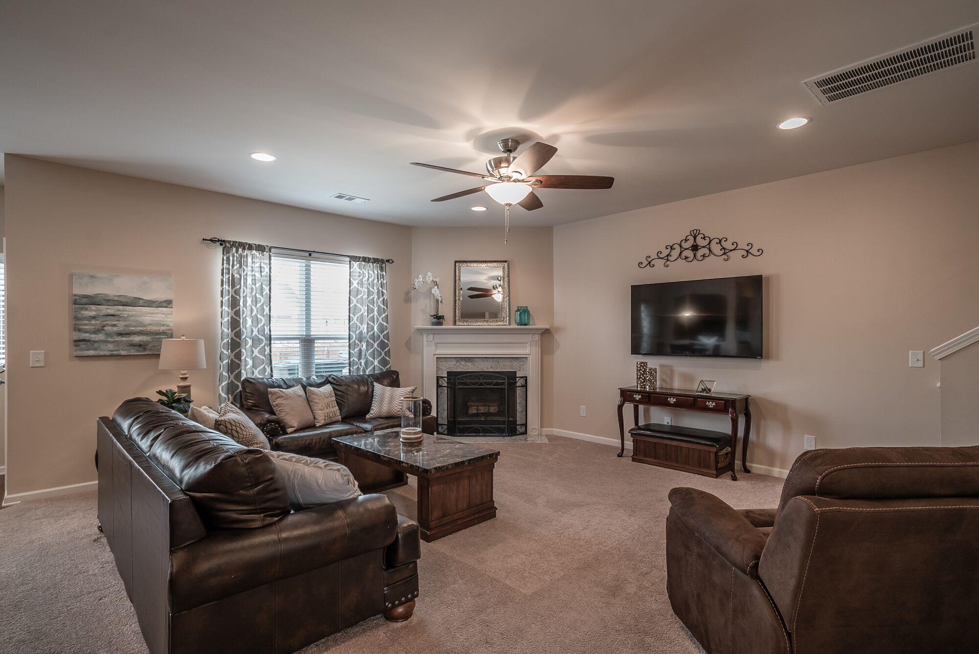 1044 Merrick Road Hendersonville, TN 37075 - Photo 11 of 27 a living room with furniture a fireplace and a flat screen tv