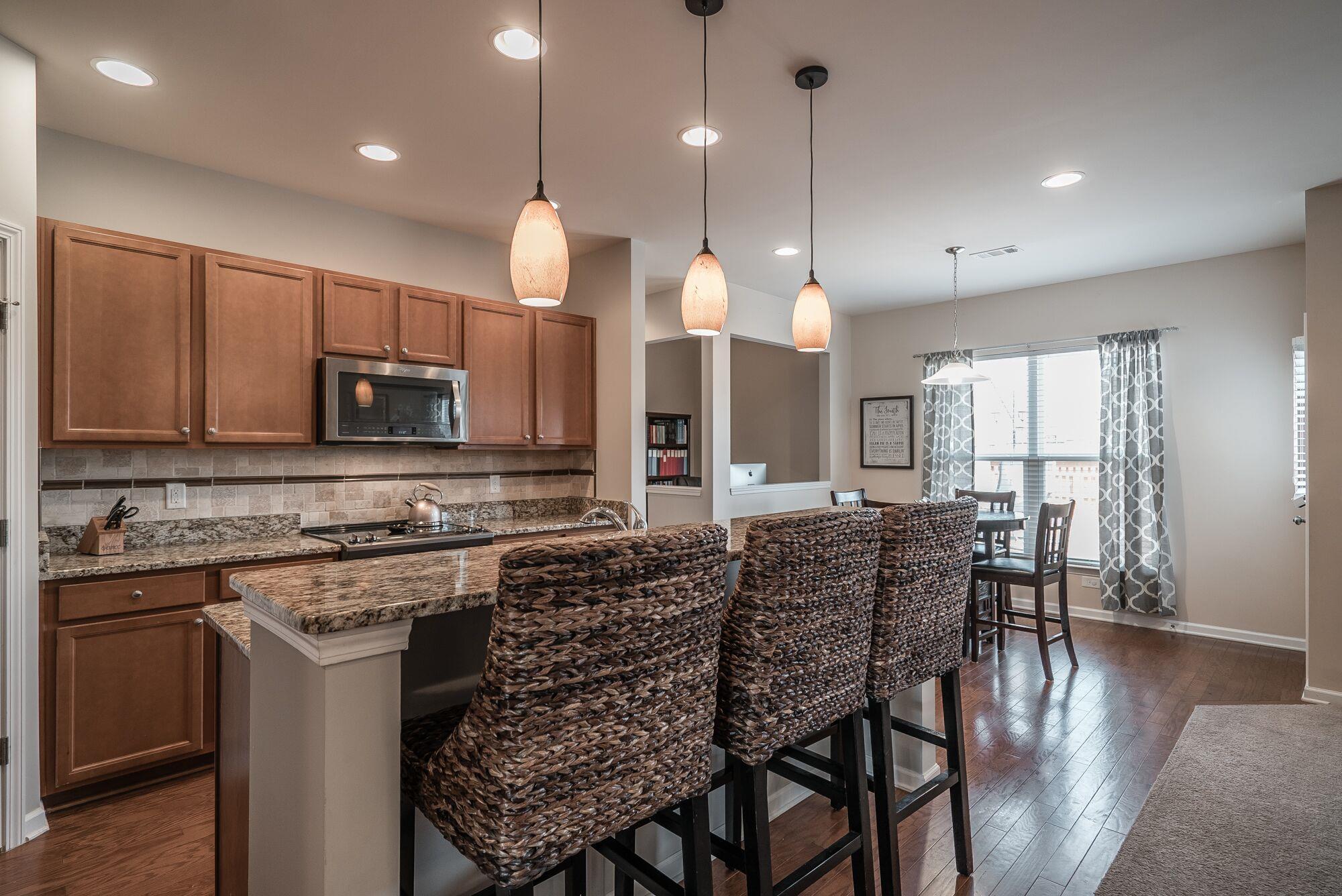1044 Merrick Road Hendersonville, TN 37075 - Photo 5 of 27 a kitchen with stainless steel appliances kitchen island granite countertop a stove a sink a oven a dining table and chairs with wooden floor