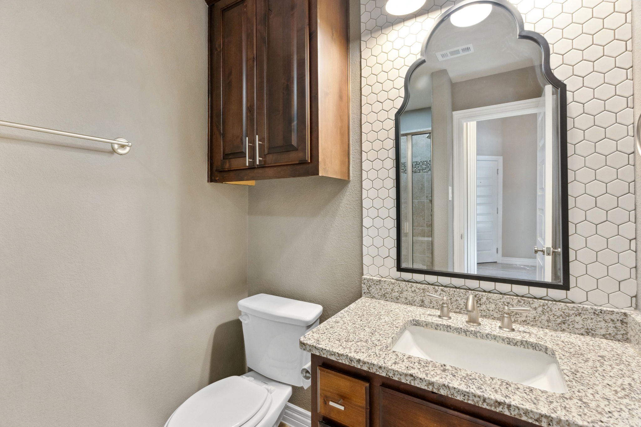 3929 Goodnight Trail Leander, TX 78641 - Photo 18 of 29 a bathroom with a granite countertop toilet sink and mirror