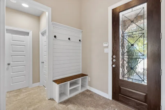 an empty room with windows and chandelier fan