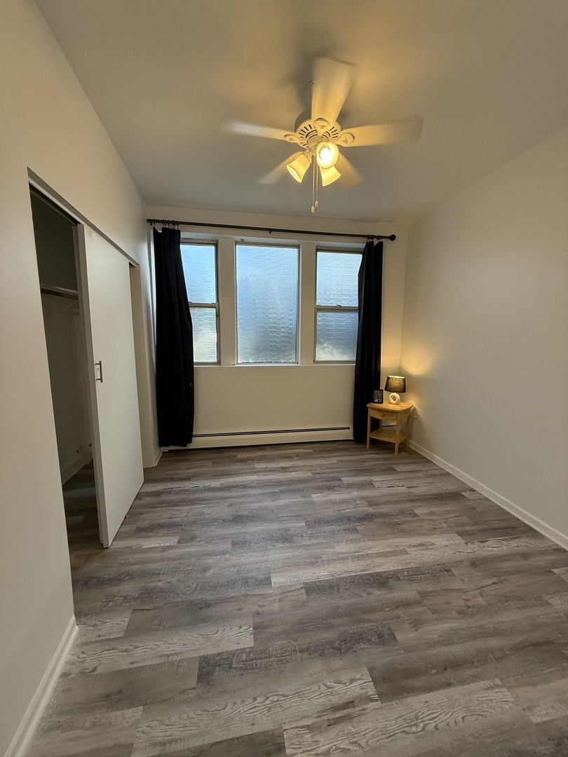 6000 West Seminole Street, Unit GDN Chicago, IL 60646 - Photo 3 of 7 an empty room with wooden floor and windows