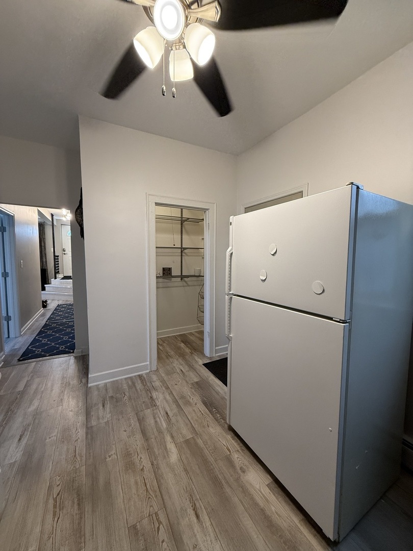 6000 West Seminole Street, Unit GDN Chicago, IL 60646 - Photo 5 of 7 a view of a kitchen with a refrigerator a ceiling fan and wooden floor