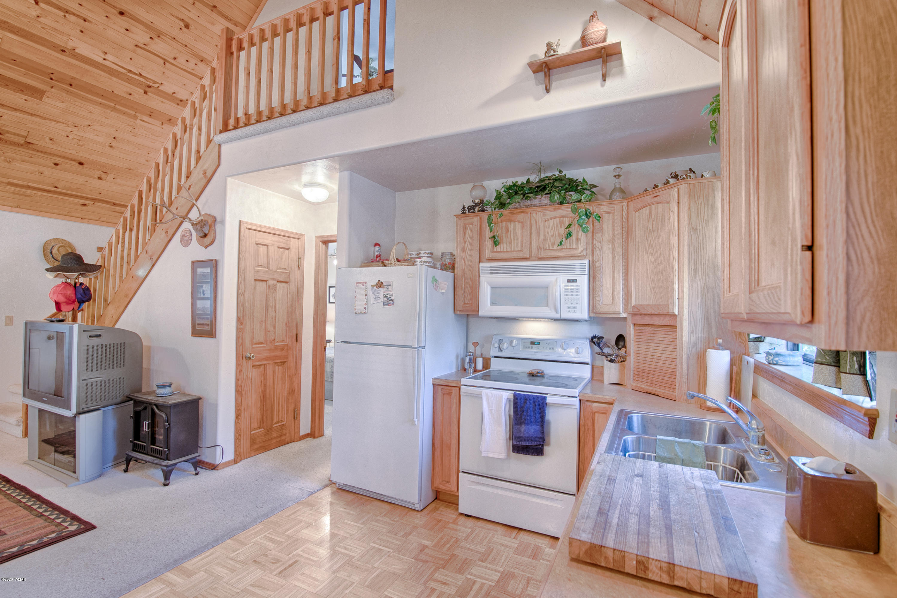 2060 Shot Gun Road Overgaard, AZ 85933 - Photo 8 of 17 a kitchen with stainless steel appliances kitchen island granite countertop a refrigerator and a stove