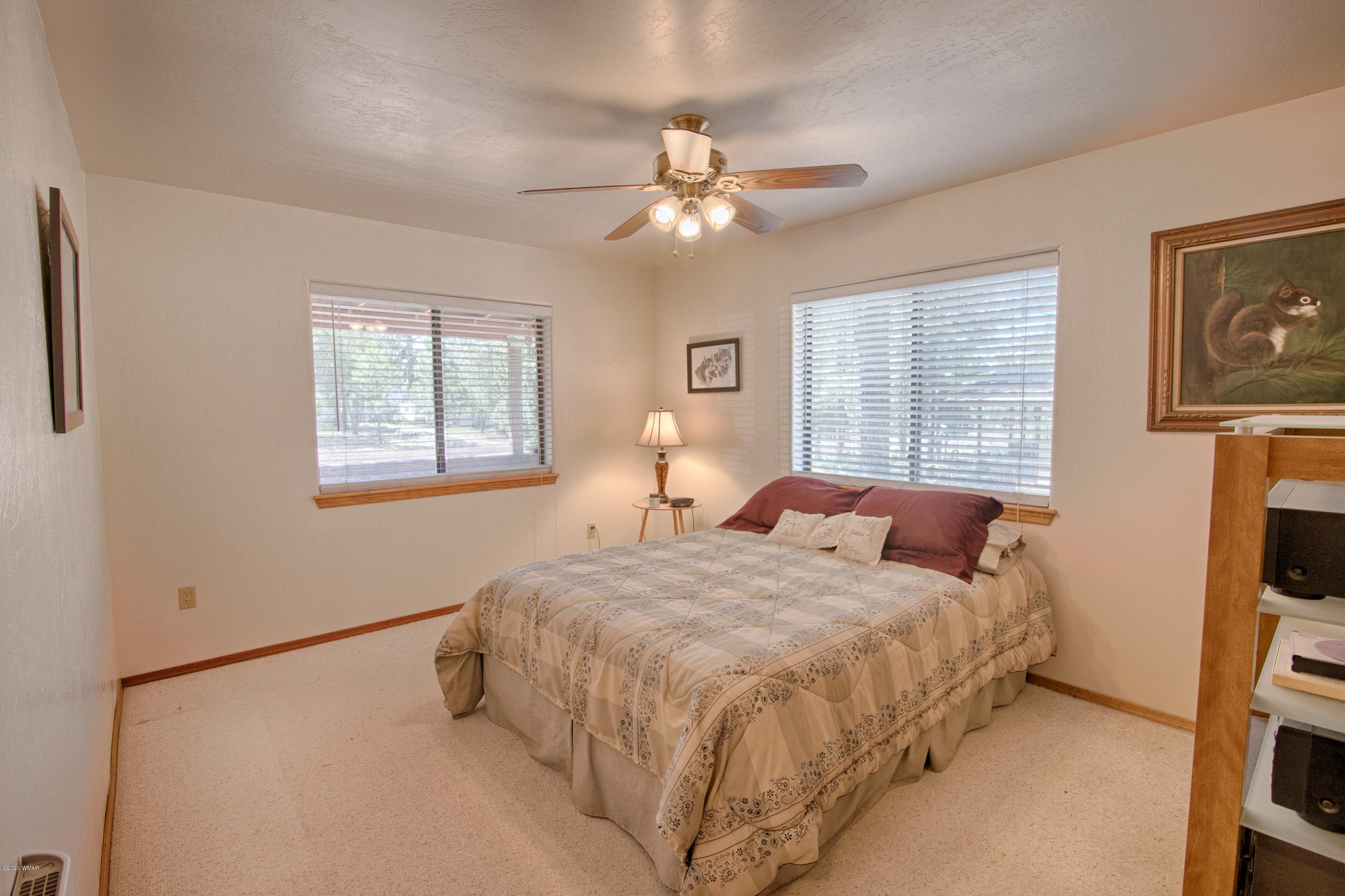 2060 Shot Gun Road Overgaard, AZ 85933 - Photo 10 of 17 a bedroom with a bed and a chandelier