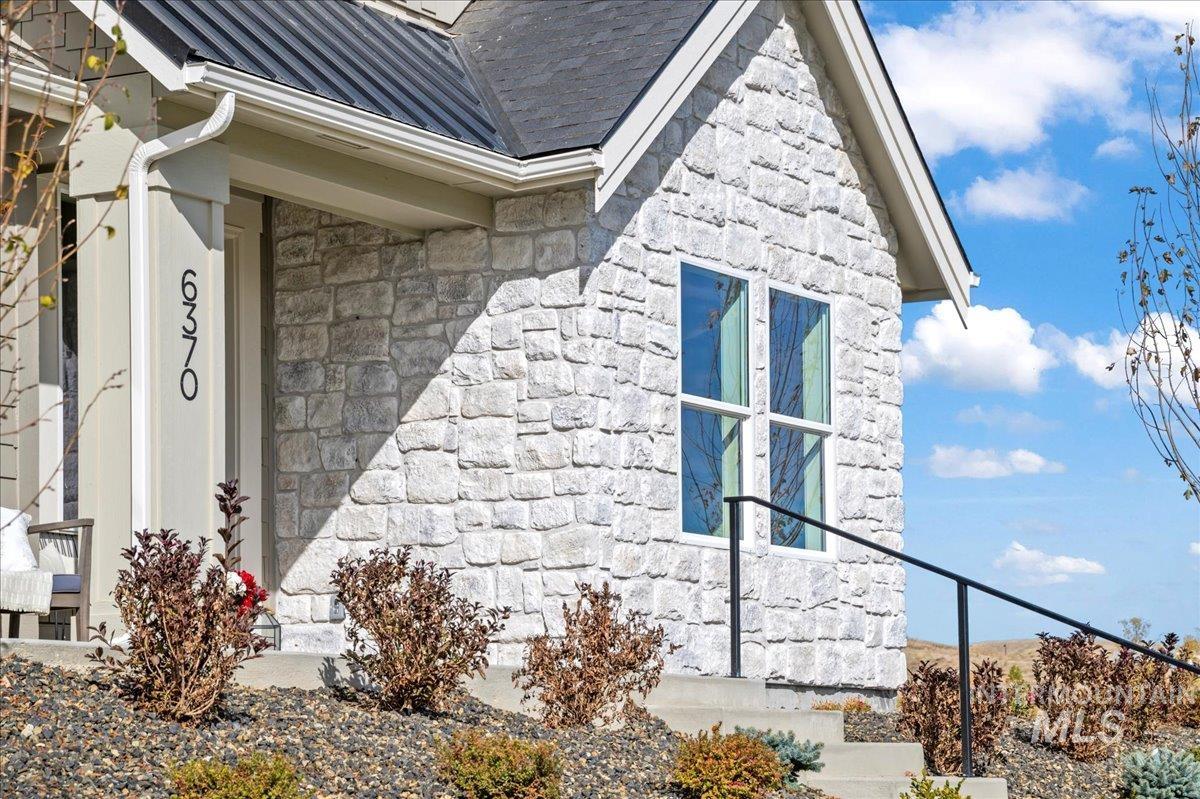 6370 North Barholm Lane Eagle, ID 83616 - Photo 20 of 33 View of side of property featuring stone siding, a metal roof, and a standing seam roof