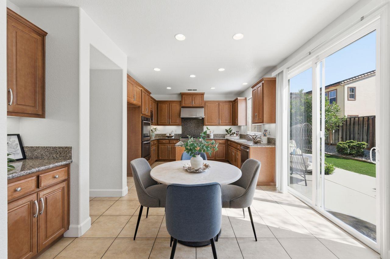 698 West Rico Way Tracy, CA 95391 - Photo 11 of 38 a kitchen with a dining table chairs and refrigerator