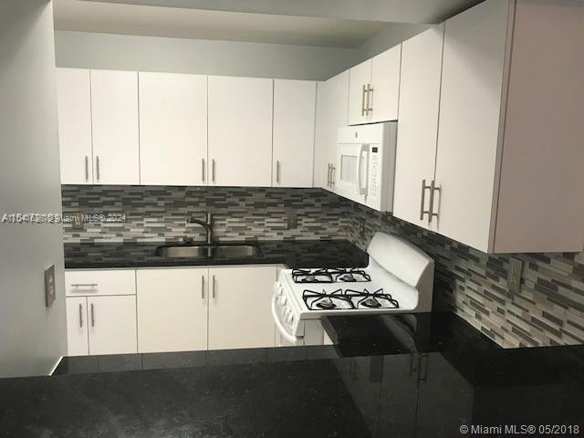 a kitchen with stainless steel appliances kitchen island sink refrigerator and stove