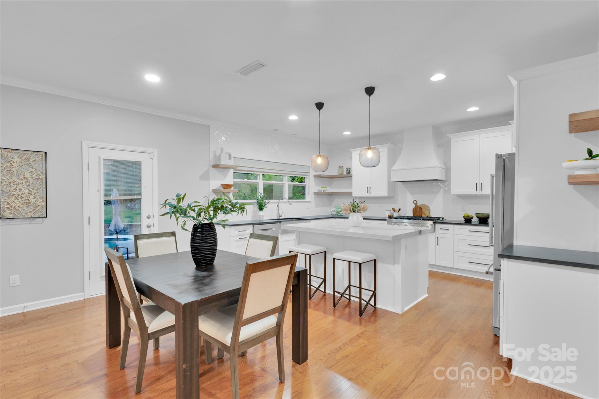 226 Bubbling Well Road Matthews, NC 28105 - Photo 14 of 47 a kitchen with a dining table chairs stove refrigerator and cabinets