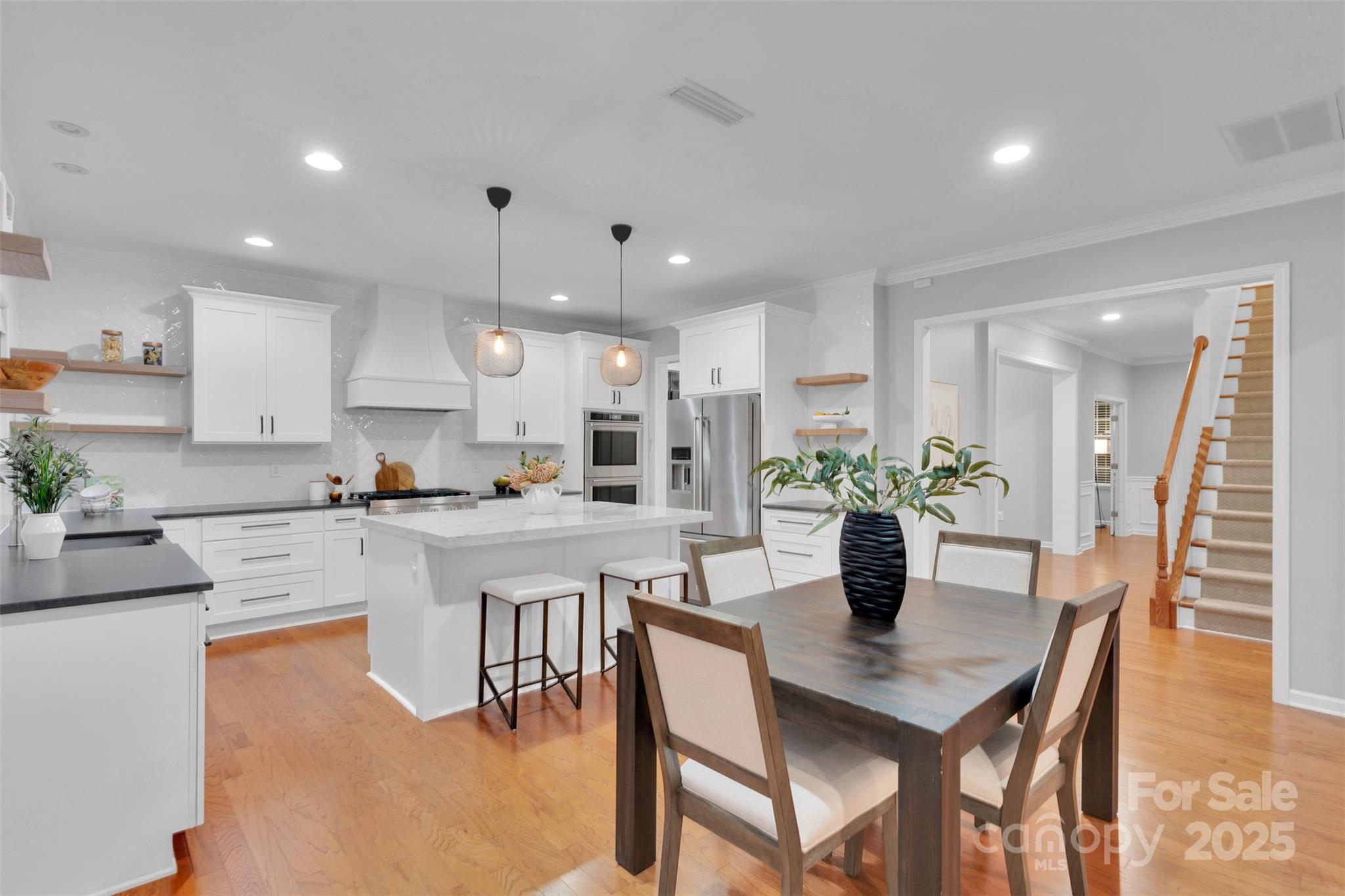 226 Bubbling Well Road Matthews, NC 28105 - Photo 15 of 47 a kitchen with a dining table chairs and white cabinets