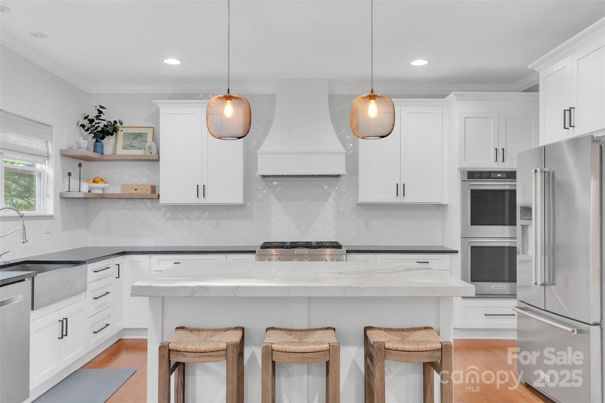 226 Bubbling Well Road Matthews, NC 28105 - Photo 16 of 47 a kitchen with stainless steel appliances granite countertop a sink a stove a refrigerator and white cabinets with wooden floor