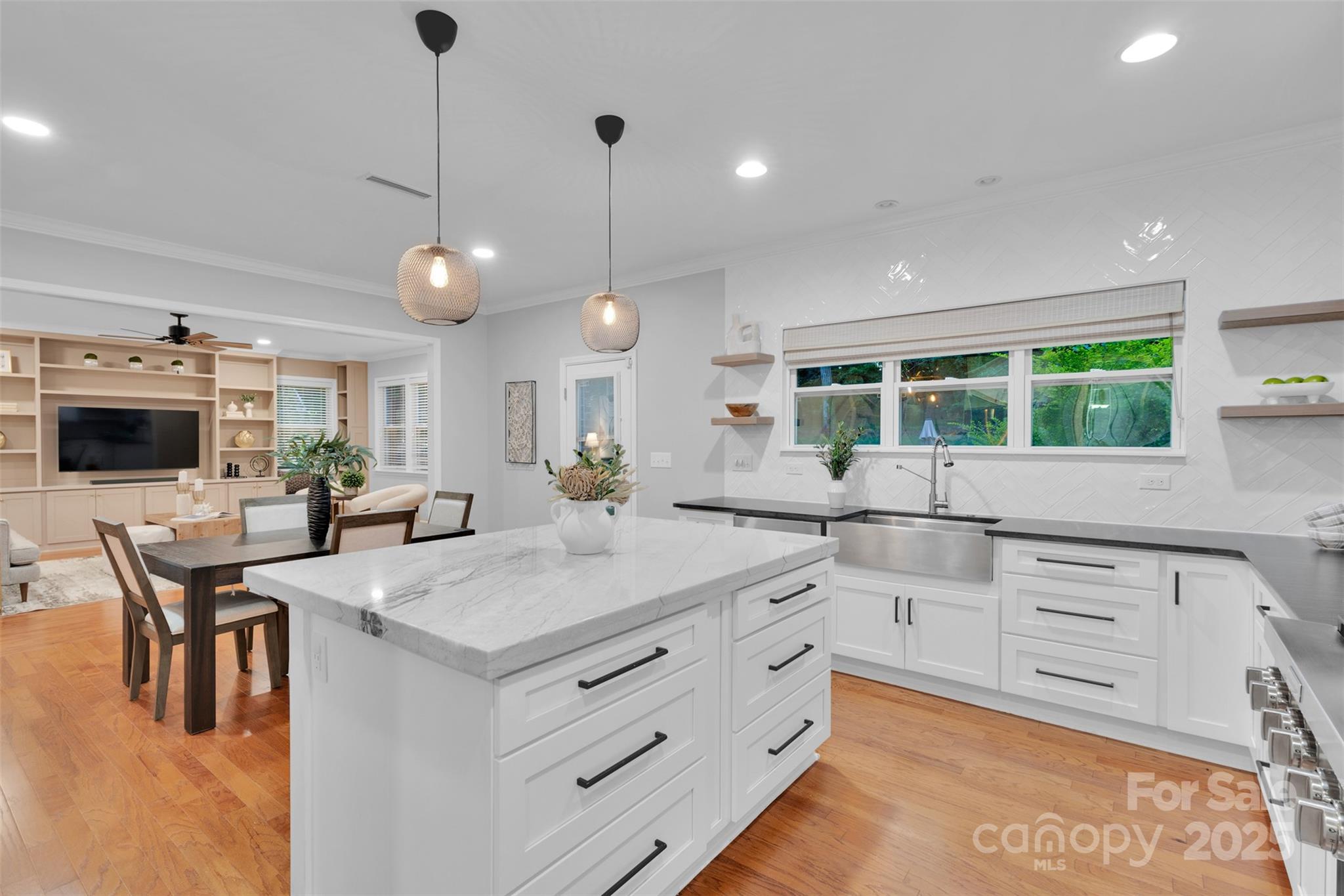 226 Bubbling Well Road Matthews, NC 28105 - Photo 17 of 47 a kitchen with stainless steel appliances kitchen island granite countertop a stove a sink a dining table and chairs with wooden floor