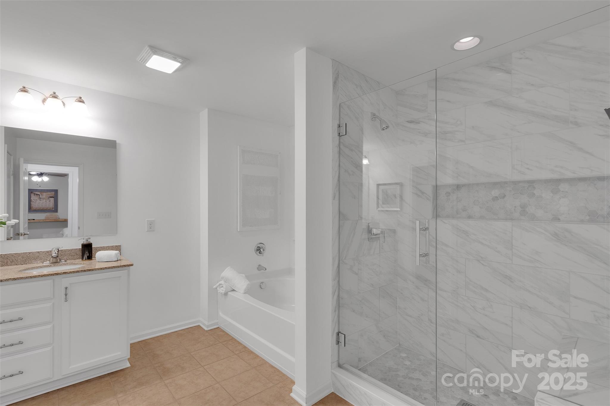 226 Bubbling Well Road Matthews, NC 28105 - Photo 32 of 47 a bathroom with a bathtub shower sink vanity and mirror