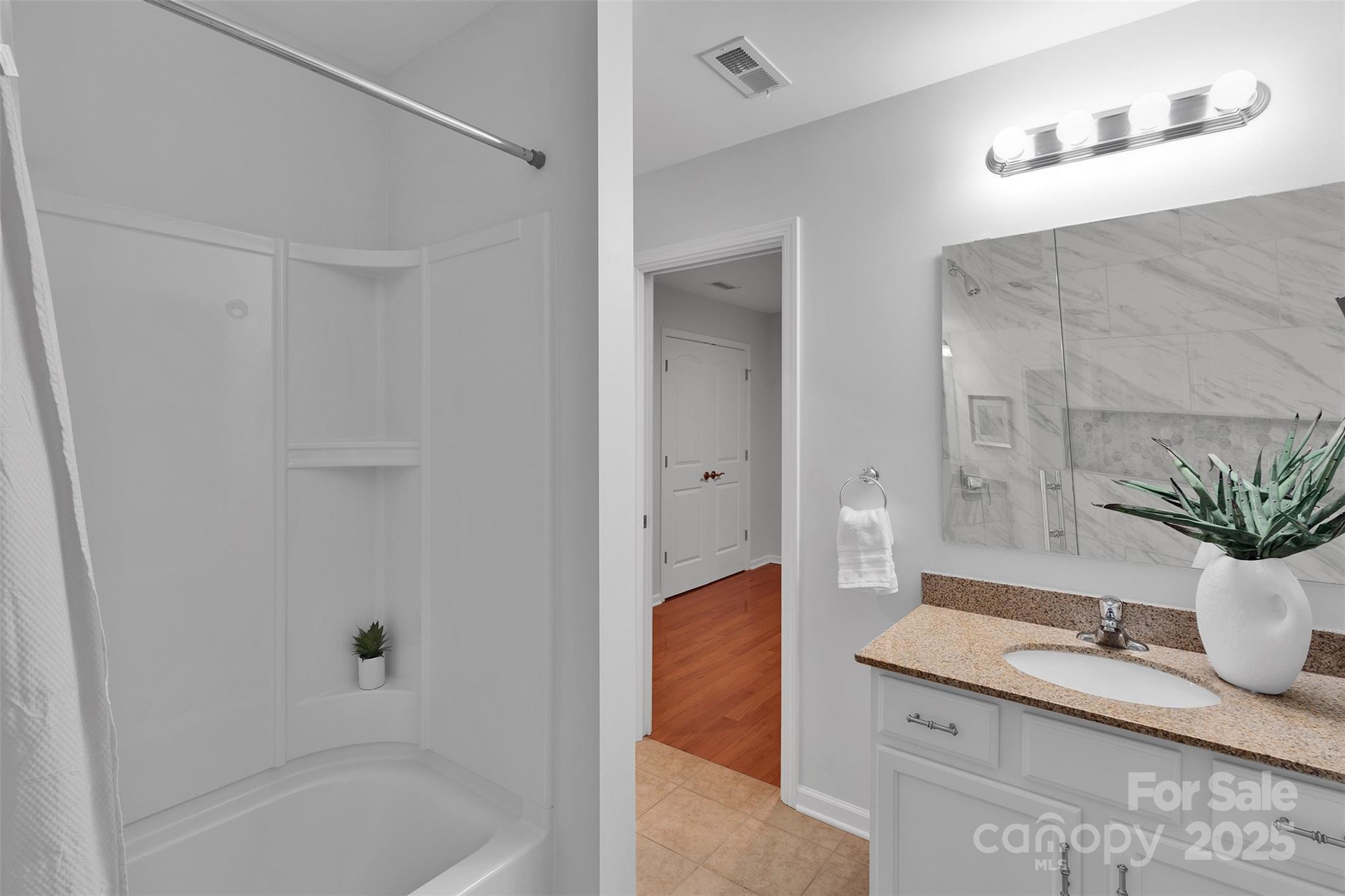 226 Bubbling Well Road Matthews, NC 28105 - Photo 42 of 47 a bathroom with a granite countertop sink and a bathtub