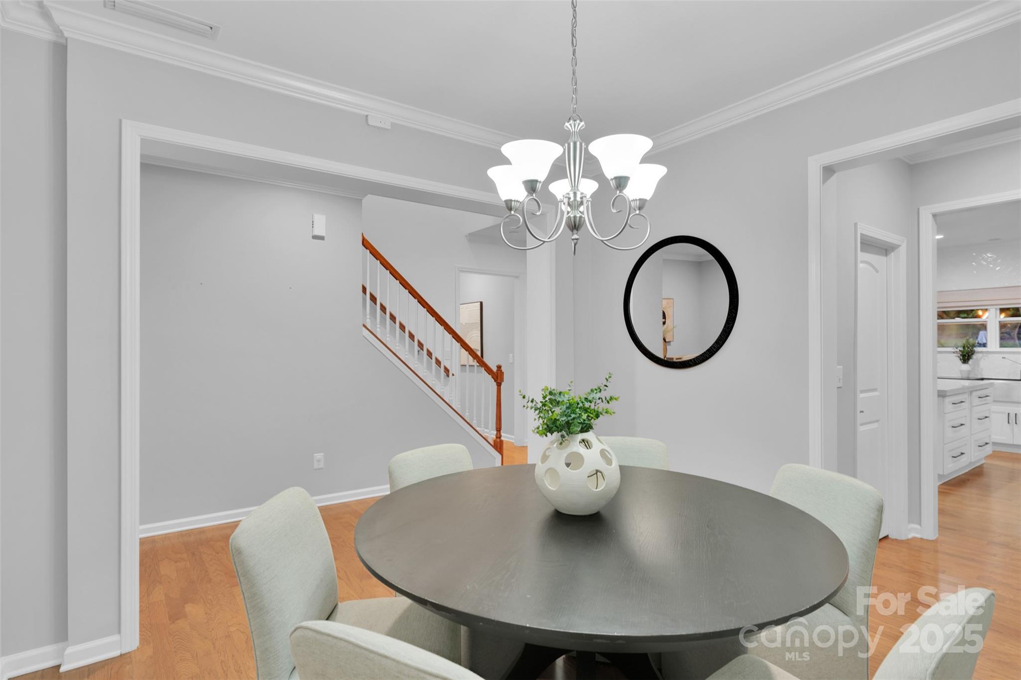226 Bubbling Well Road Matthews, NC 28105 - Photo 10 of 47 a view of a dining room with furniture a chandelier and wooden floor