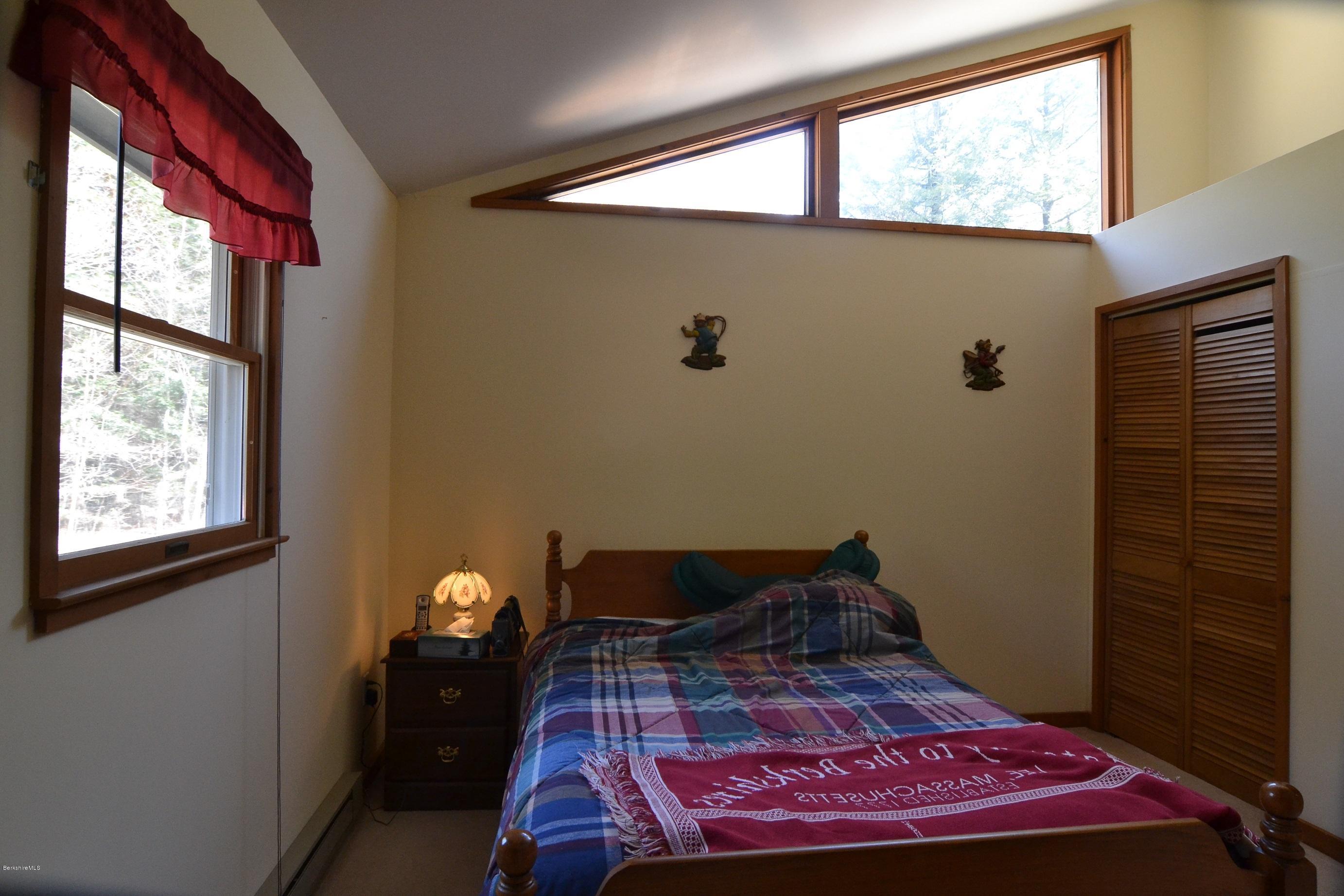 3008 Jacobs Ladder Road Becket, MA 01223 - Photo 15 of 28 a bed sitting in a bedroom next to a window