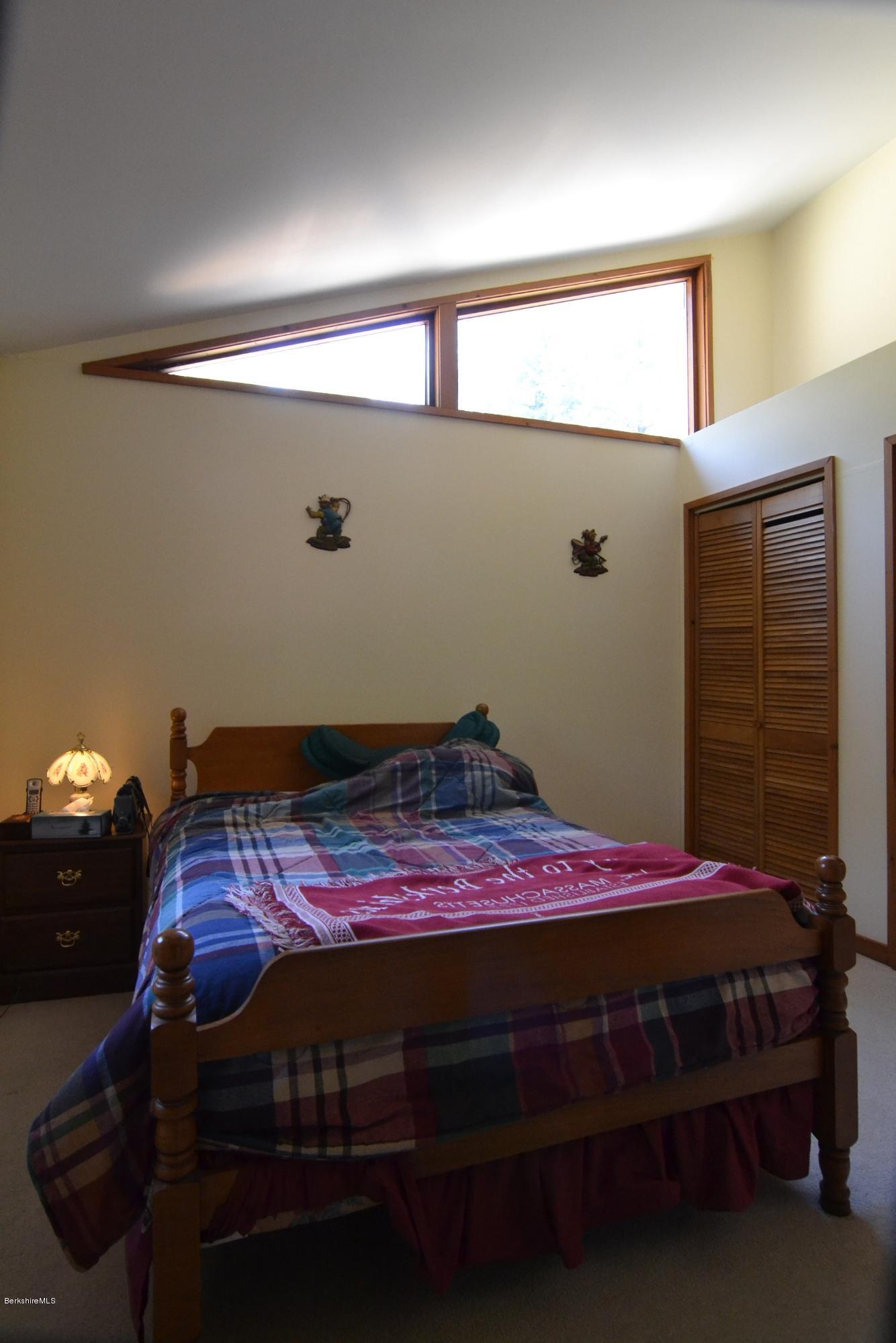3008 Jacobs Ladder Road Becket, MA 01223 - Photo 16 of 28 a bed sitting in a bedroom next to a window