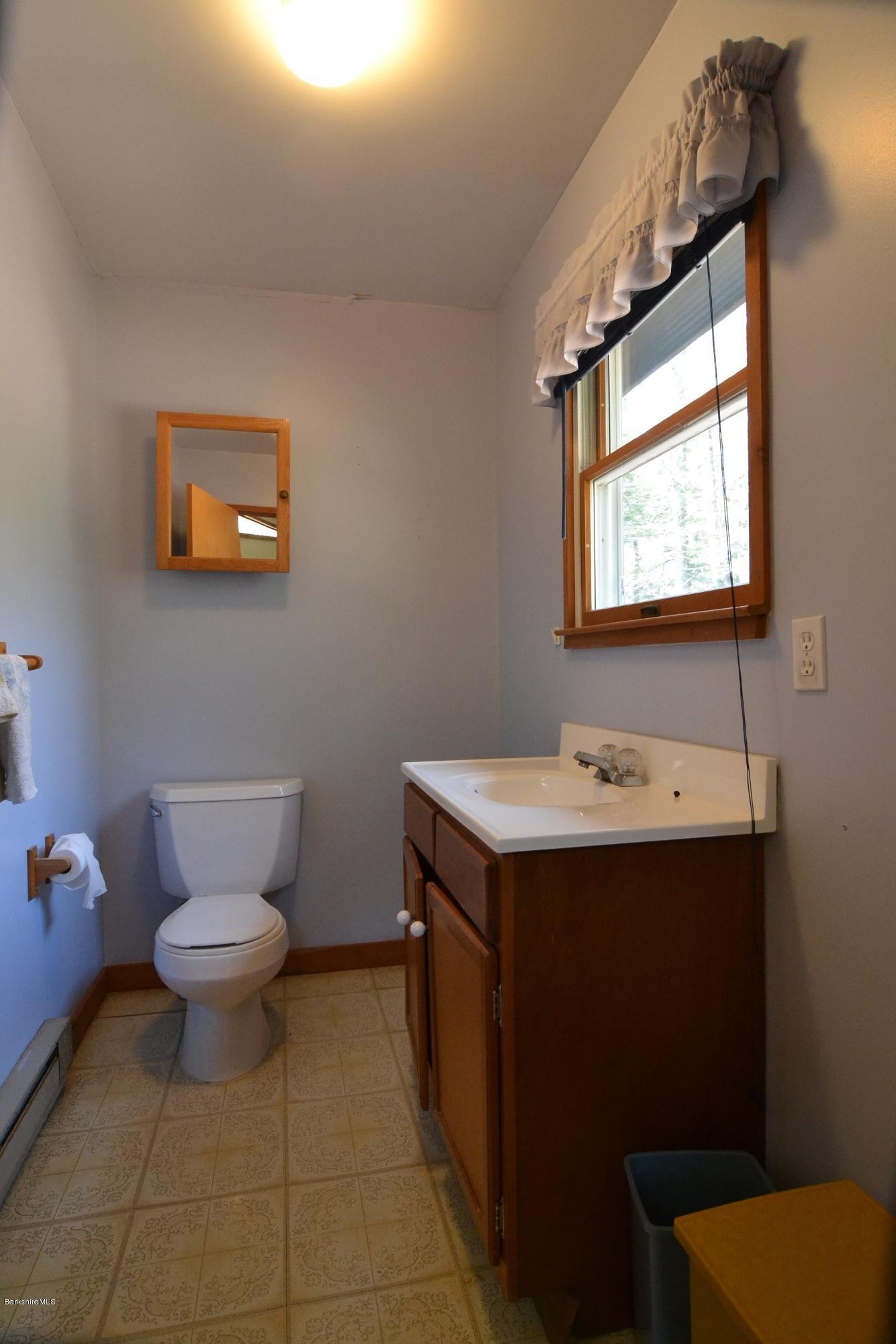 3008 Jacobs Ladder Road Becket, MA 01223 - Photo 18 of 28 a bathroom with a toilet sink and mirror
