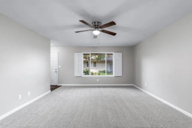 a view of room with a ceiling fan and window