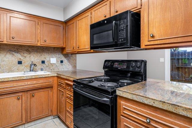 617 West Granger Avenue Modesto, CA 95350 - Photo 7 of 23 a kitchen with stainless steel appliances granite countertop a stove and a microwave