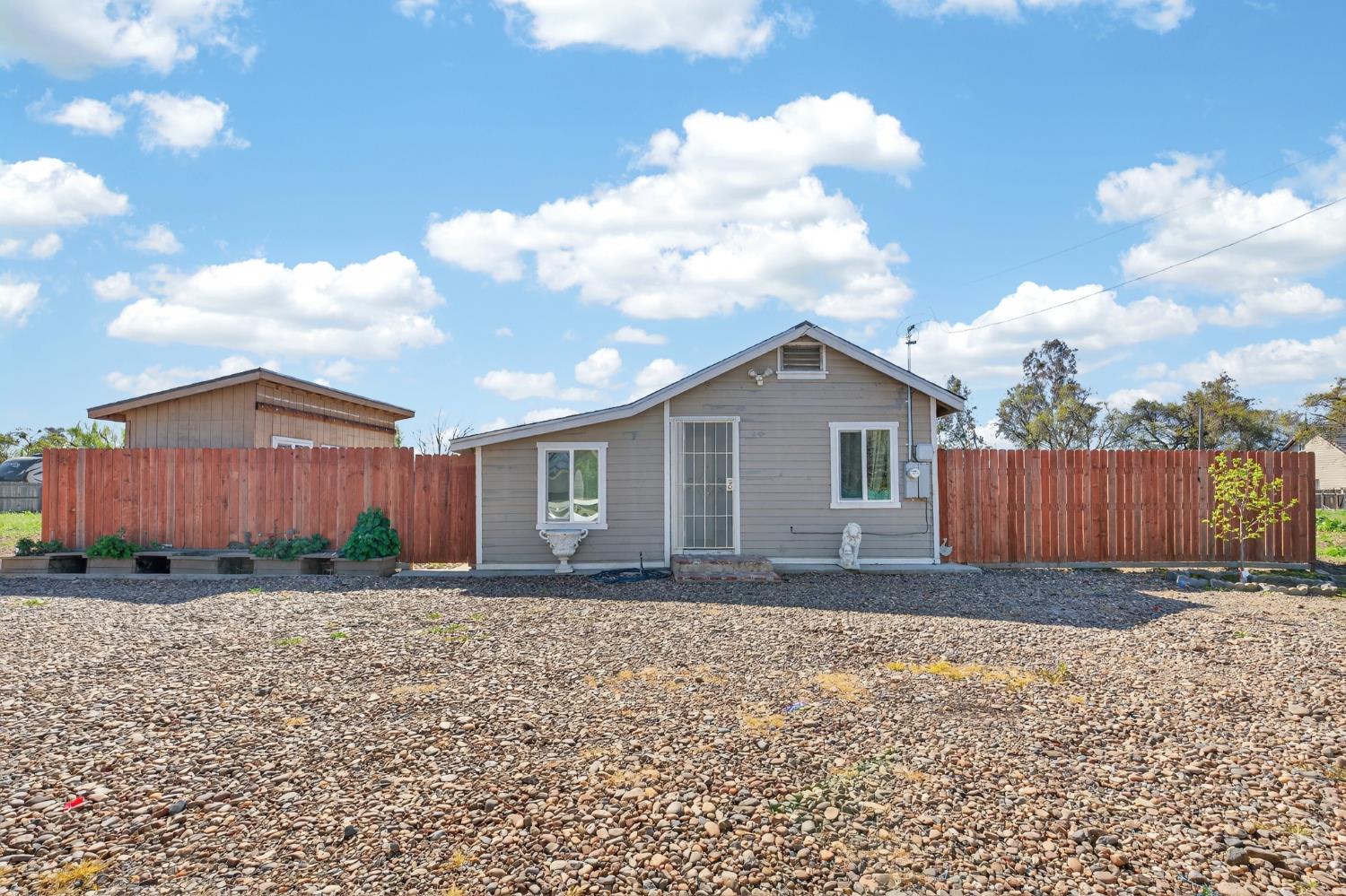 a view of a house with a yard and wooden fence