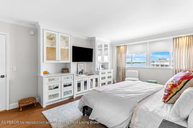 a living room with furniture a wooden floor and a large window