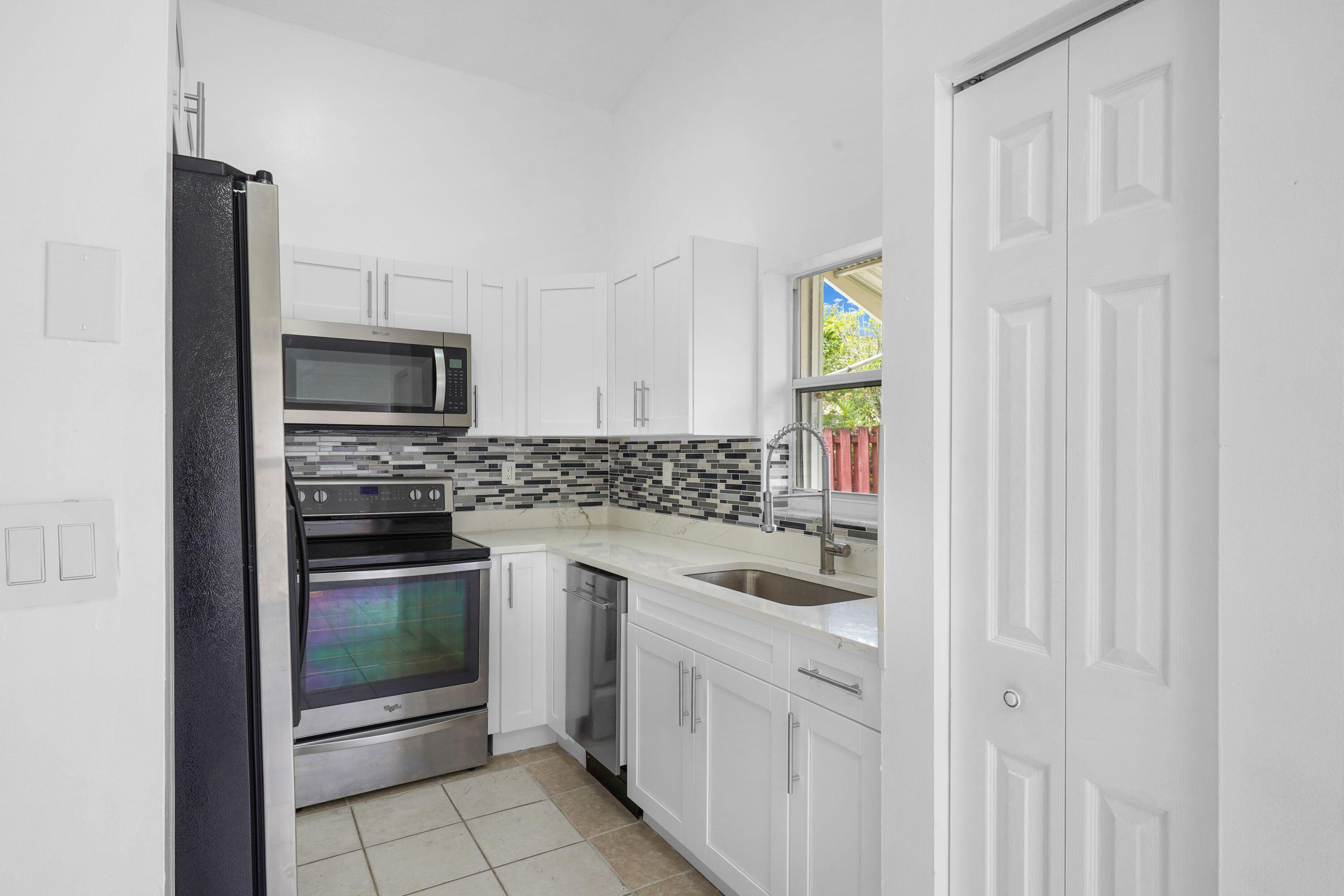 14142 Southwest 149th Court Miami, FL 33196 - Photo 11 of 48 a kitchen with white cabinets and appliances