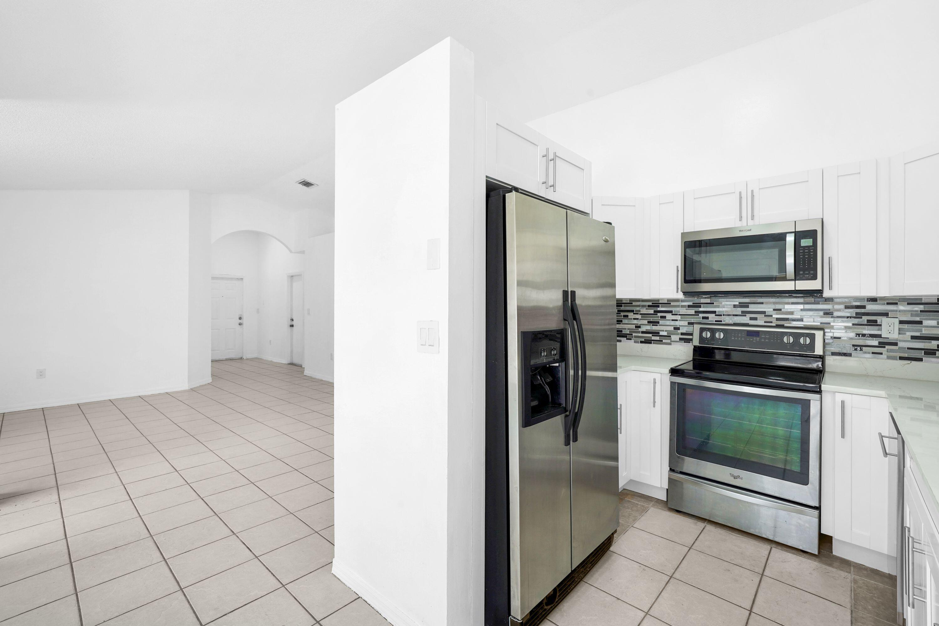 14142 Southwest 149th Court Miami, FL 33196 - Photo 13 of 48 a view of a kitchen with a sink and a stove top oven