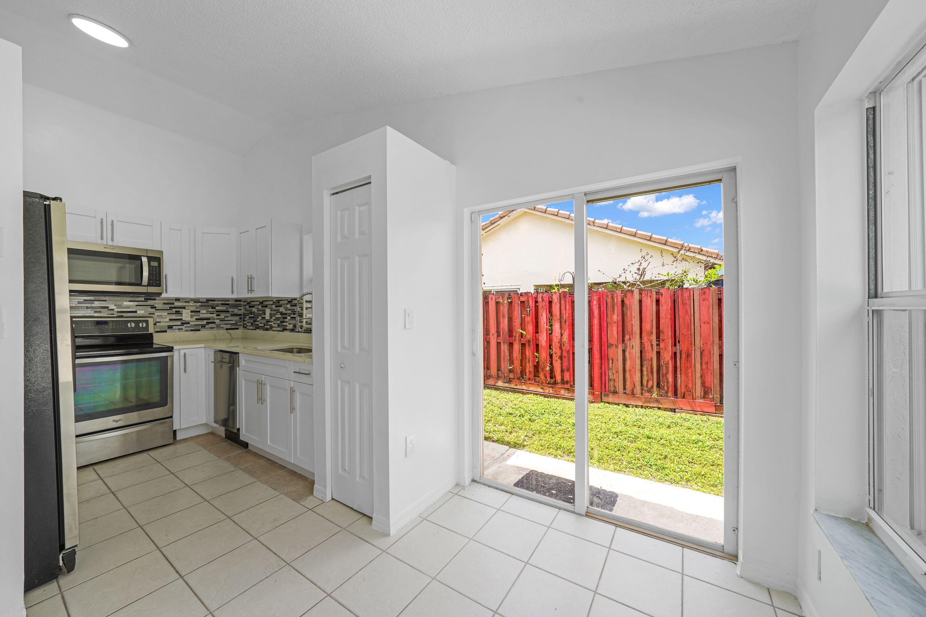 14142 Southwest 149th Court Miami, FL 33196 - Photo 10 of 48 a kitchen with a sink a counter top space and stainless steel appliances
