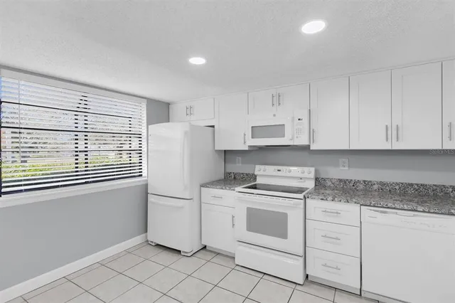 a kitchen with white cabinets and white appliances