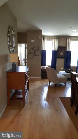a living room with furniture a desk and chair with wooden floor