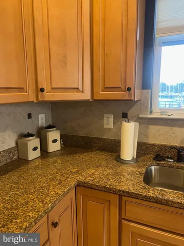 a kitchen with granite countertop white cabinets and a sink