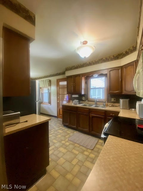 3565 Palmyra Road Southwest Warren, OH 44481 - Photo 9 of 31 Kitchen featuring backsplash, sink, dark brown cabinets, and light tile floors