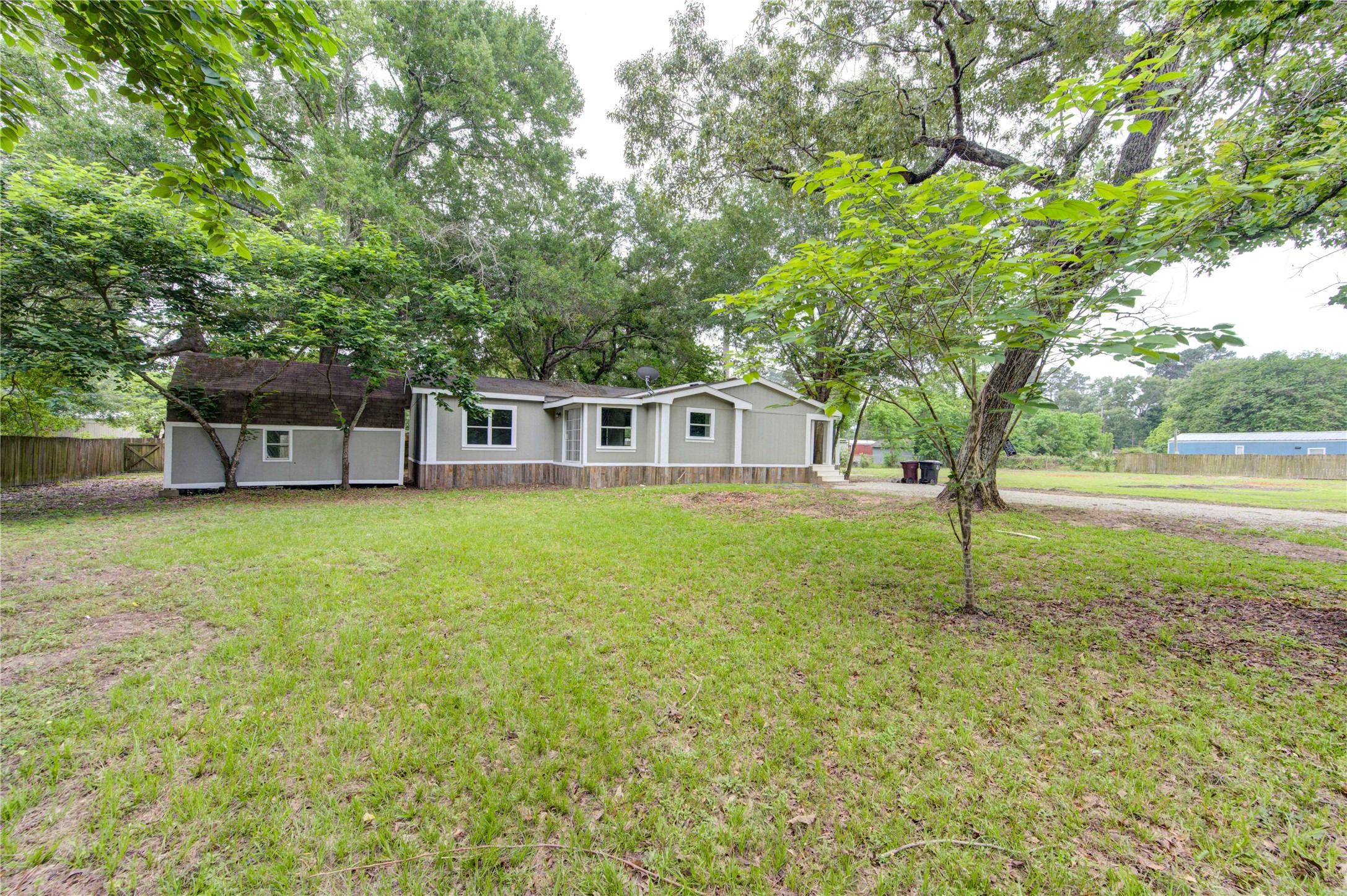 30226 Davis Street Magnolia, TX 77355 - Photo 48 of 50 Charming single-story home surrounded by mature trees, offering a spacious front yard and a peaceful, natural setting. Ideal for those seeking tranquility and a connection with nature.