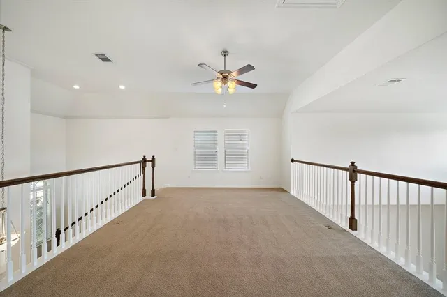 a view of a hallway with a ceiling fan