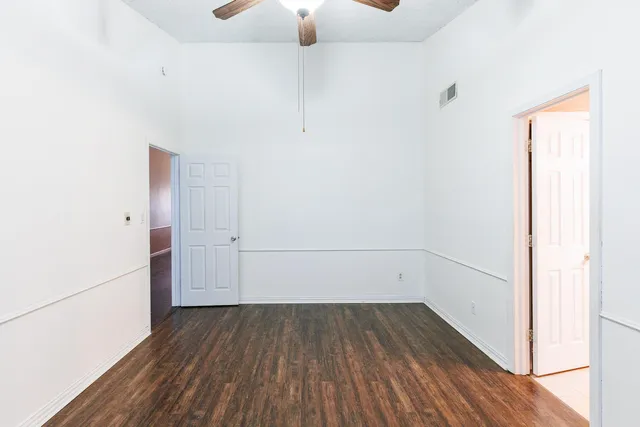 a view of a room with wooden floor and white walls