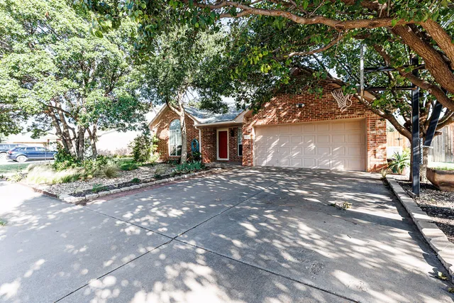 a front view of a house with a tree